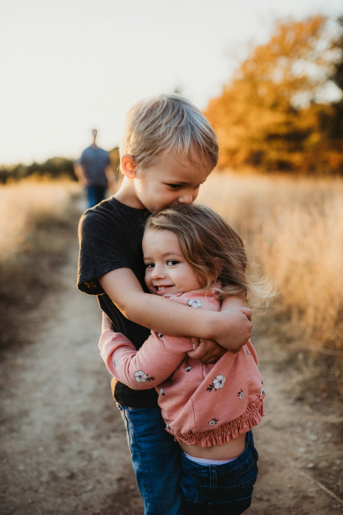 Young boy hugging his sister