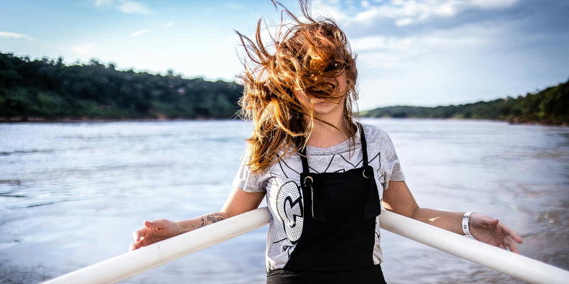 Boat insurance - Woman leaning against the railing on the bow of a boat.
