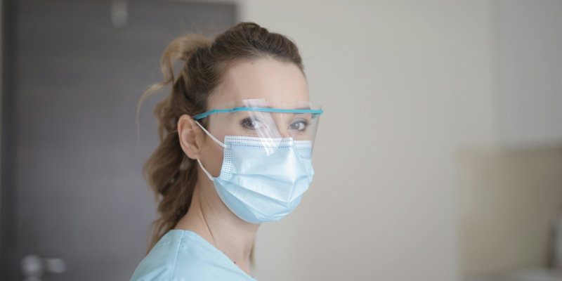 Health insurance - Doctor wearing a mask and safety glasses.