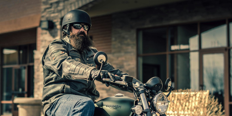 Motorcycle insurance - Man with helmet riding motorcycle.